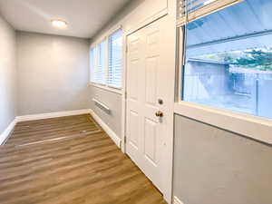 Back hall features a closed trap door to the basement, new light fixture, new paint, new windows, and new blinds