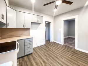 Kitchen with new flooring, light gray cabinets, and a new ceiling fan