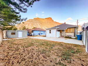 Rear view of the house with a mountain view, patio area, and fenced yard