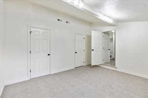 Carpeted empty room with a textured ceiling