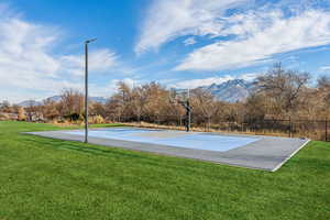 View of basketball court with a lawn and a mountain view