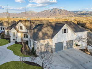 View of front of property featuring a mountain view, a front yard, and a garage