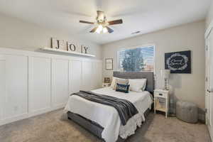 Carpeted bedroom featuring ceiling fan