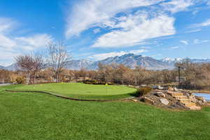 View of property's community with a mountain view and a lawn