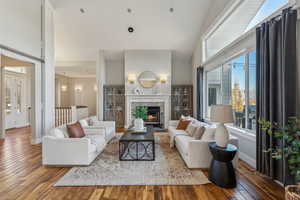 Living room featuring hardwood / wood-style floors, a stone fireplace, and plenty of natural light