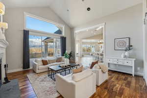 Living room featuring high vaulted ceiling and dark wood-type flooring