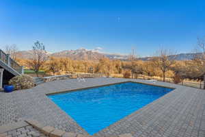 View of swimming pool with a mountain view and a patio area