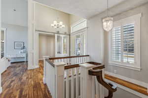 Hall with a chandelier and dark hardwood / wood-style floors