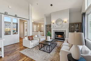 Living room with wood-type flooring and high vaulted ceiling