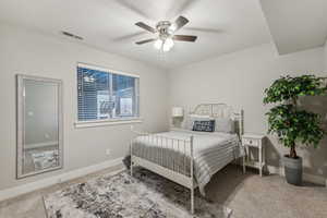 Bedroom with light carpet, a textured ceiling, and ceiling fan