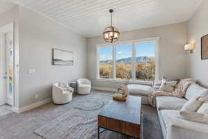 Carpeted living room with a chandelier, a mountain view, and wooden ceiling