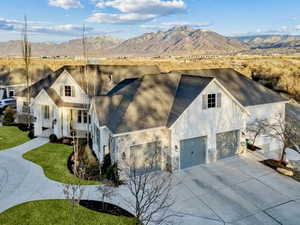 View of front facade featuring a mountain view, a garage, and a front lawn