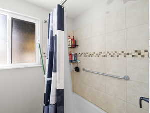 Bathroom featuring shower / bath combination with curtain