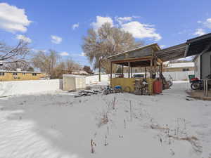 Yard covered in snow with a storage shed