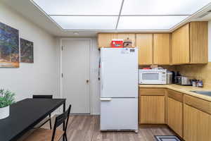 Kitchen with white appliances and hardwood / wood-style flooring