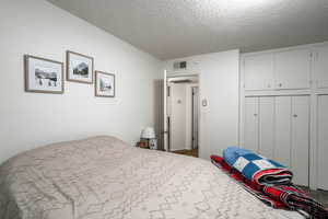 Bedroom featuring carpet and a textured ceiling