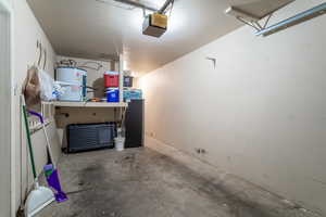 Garage featuring electric water heater and a garage door opener