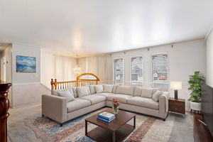 Carpeted living room with a notable chandelier