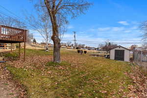 View of yard with a storage unit and a wooden deck