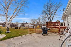 View of patio with a deck and a grill