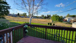 Deck featuring a rural view and a lawn