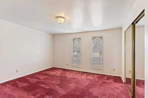 Unfurnished bedroom with carpet flooring and a closet