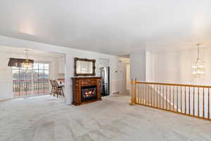 Carpeted living room with a notable chandelier