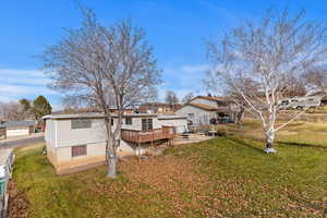 Back of house with a yard and a wooden deck