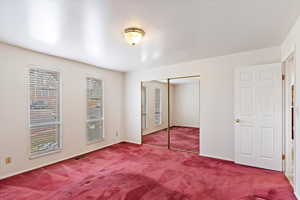 Unfurnished bedroom featuring a closet and carpet