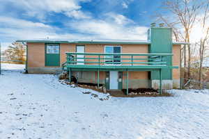 Snow covered property with a deck