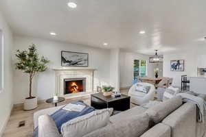 Living room with a chandelier, a premium fireplace, and light hardwood / wood-style floors