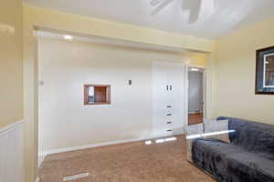 Carpeted living room featuring ceiling fan