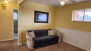 Sitting room featuring carpet flooring and ceiling fan, was at one time a 3rd bedroom upstairs