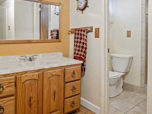 Bathroom with tile patterned floors, vanity, and toilet