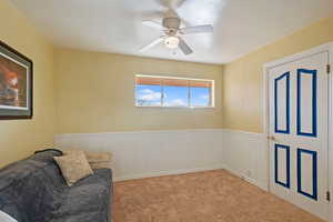 Living area/TV room/home office featuring light carpet and ceiling fan