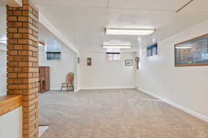 Basement featuring light carpet