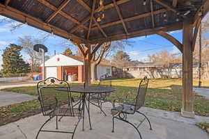 View of patio with an basketball hoop, a gazebo, and a garage