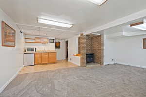 basement living room with light colored carpet and indoor wet bar