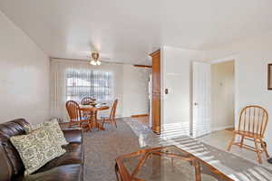 Living room and dining space, with ceiling fan and light tile patterned flooring