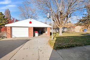 2 car Garage featuring a lawn, mature tree