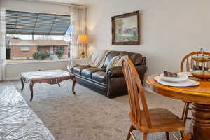 Carpeted living room with dining room