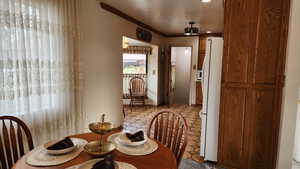 Dining room with tile patterned floors and crown molding