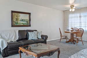 Living room with carpet flooring and ceiling fan