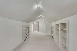 Bonus room featuring light carpet and vaulted ceiling