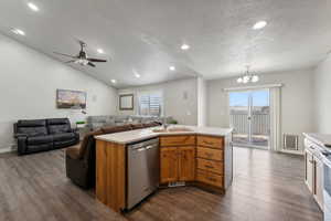 Kitchen with a wealth of natural light, a center island with sink, and stainless steel appliances