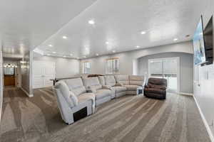 Carpeted living room featuring a textured ceiling