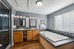 Bathroom with hardwood / wood-style flooring, vanity, and separate shower and tub