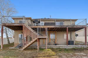 Rear view of house with cooling unit and a wooden deck