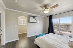 Bedroom featuring ceiling fan, ornamental molding, dark wood-type flooring, and access to outside