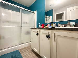 Bathroom with a shower with door and vanity